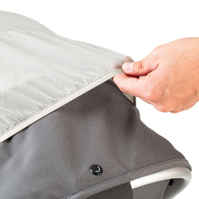 Hand pulling the mosquito net over a stroller